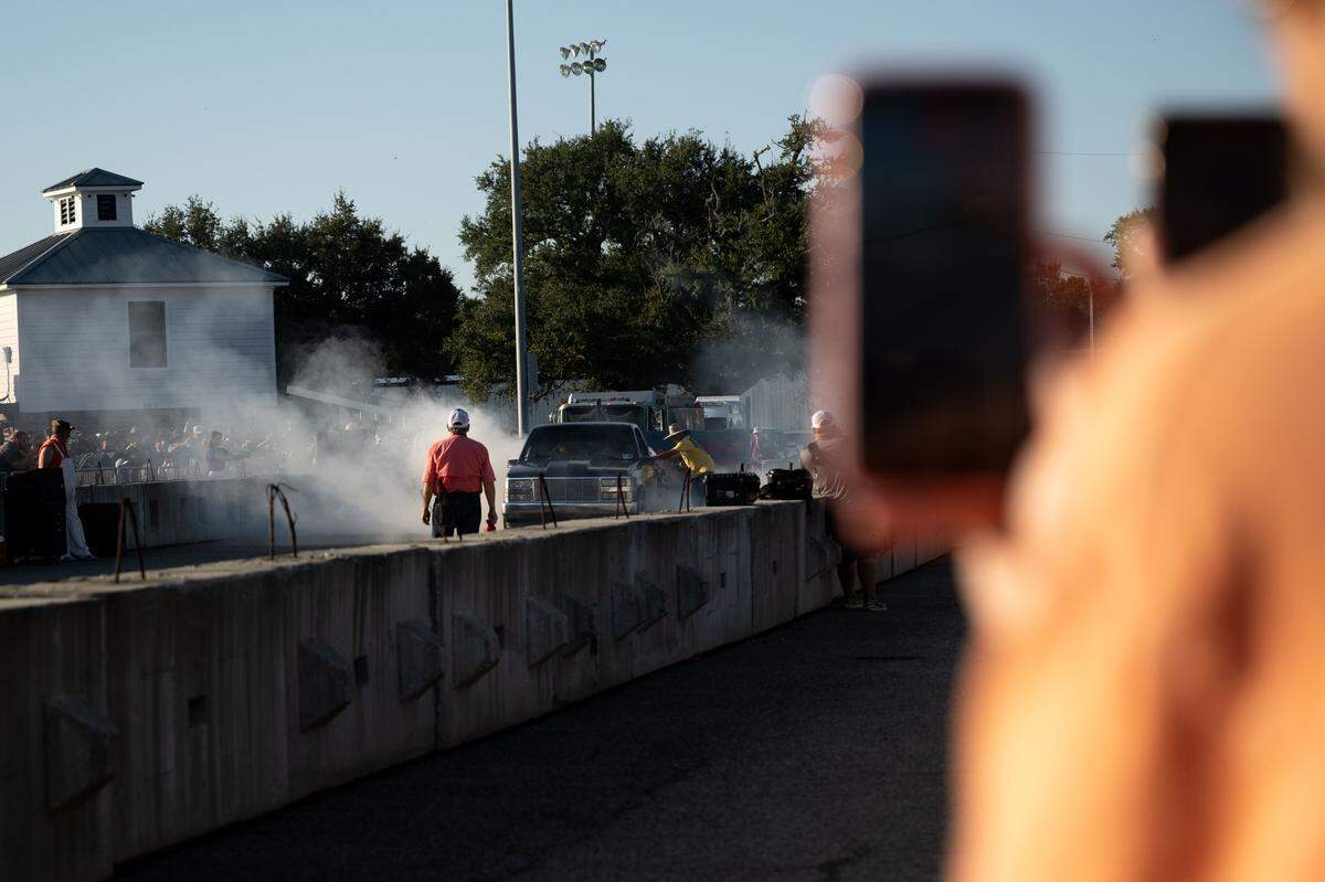 Event attendees take pictures and videos as cars come out during Burn ‘Em Up In The Pass on Thursday, Oct. 9, 2025.