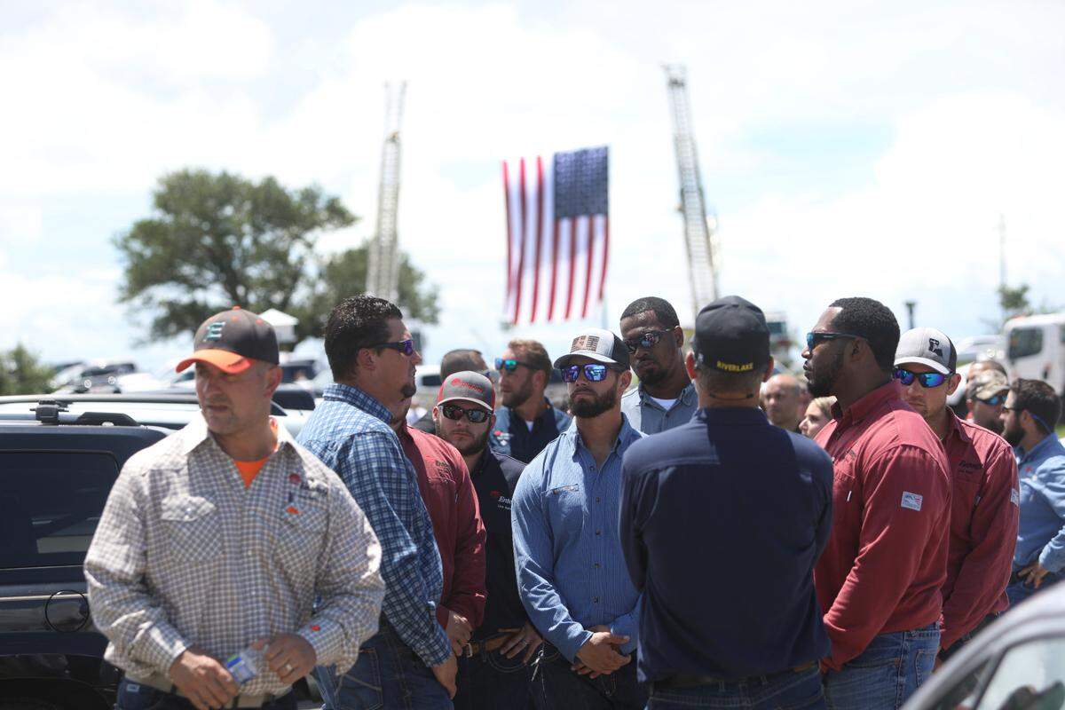Hundreds wait outside St. Clare Catholic Church, including many linemen and first responders, to pay respects to lineman Cayce Seal on July 1, 2021. Entergy crews and Bay St. Louis firefighters raised three American flags and a cross on the church property in Waveland.