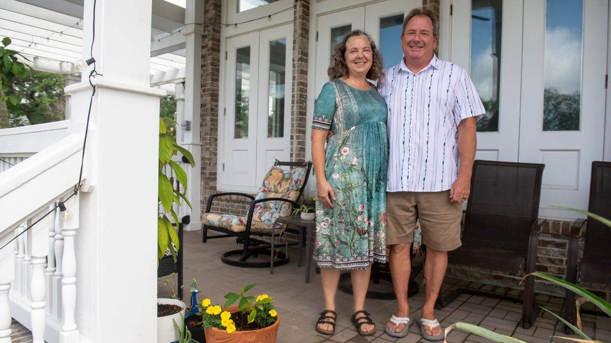 Heidi and Dan Hoye pose for a portrait on the front porch of their Biloxi home on Wednesday, May 14, 2025. The Hoyes bought the home with the intention of turning it into a bed and breakfast, but permission has been stalled in court after neighbors appealed the city’s approval.