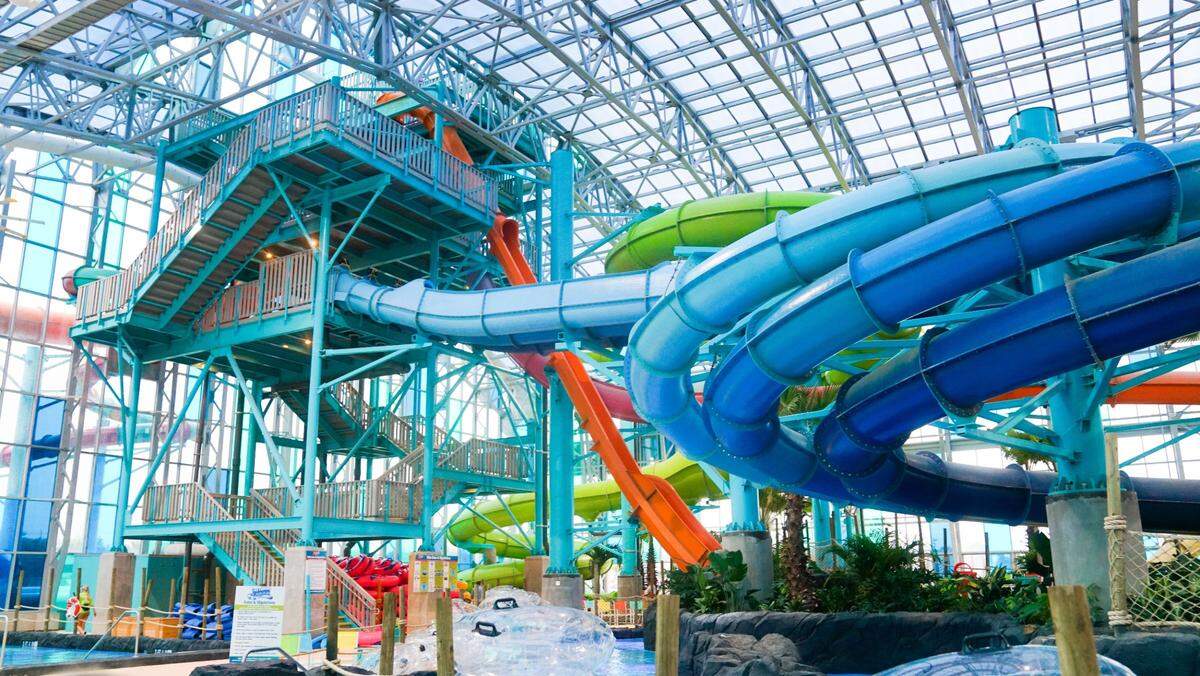 Colorful waterslides curl overhead at Tropic Falls indoor waterpark at OWA in Foley, Ala. A wave pool will open by the end of the summer.