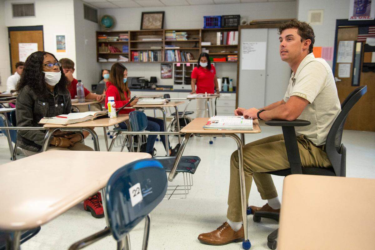 Hayden Roberts, a history teacher at Pascagoula High School, reads from a textbook in English to his class on Monday, Oct. 25, 2021.