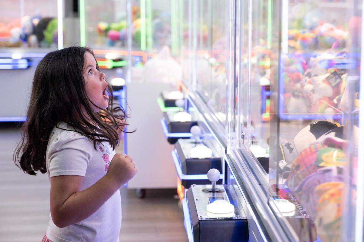 Audrey Lopez, 6, reacts after winning a toy on a claw machine at Hippie Fish at Centennial Plaza in Gulfport on Thursday, June 26, 2025.
