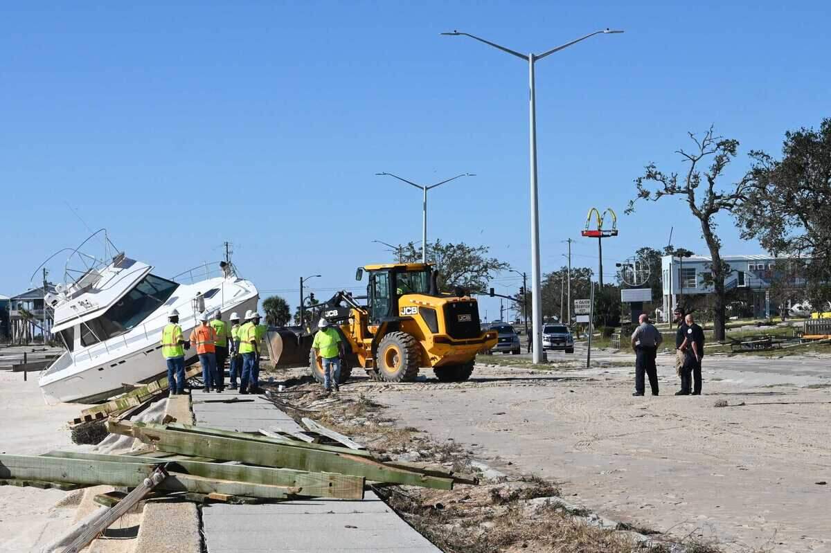 A crew works to retrieve a boat that washed up near Highway 90 in Long Beach, Mississippi Oct. 29, 2020. Hurricane Zeta ripped through the Gulf Coast overnight leaving major debris and flooding in its path.