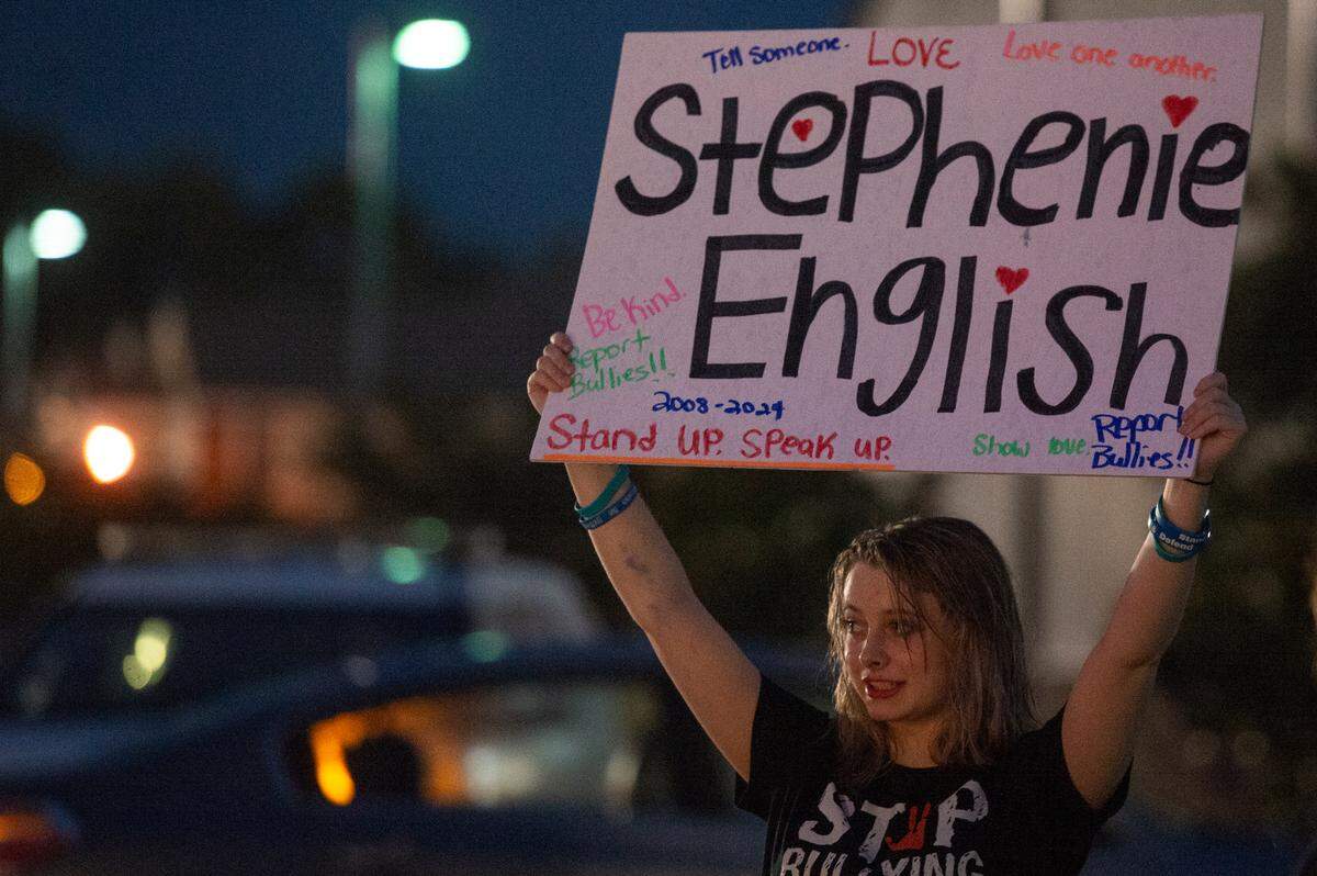 Maddison English stands outside the D’Iberville High School football game at Warrior Stadium on Friday, Oct. 4, 2024, to draw attention to the death of her cousin, Stephenie “Stevie” English. Stevie, 16, died by suicide in September after being bullied.