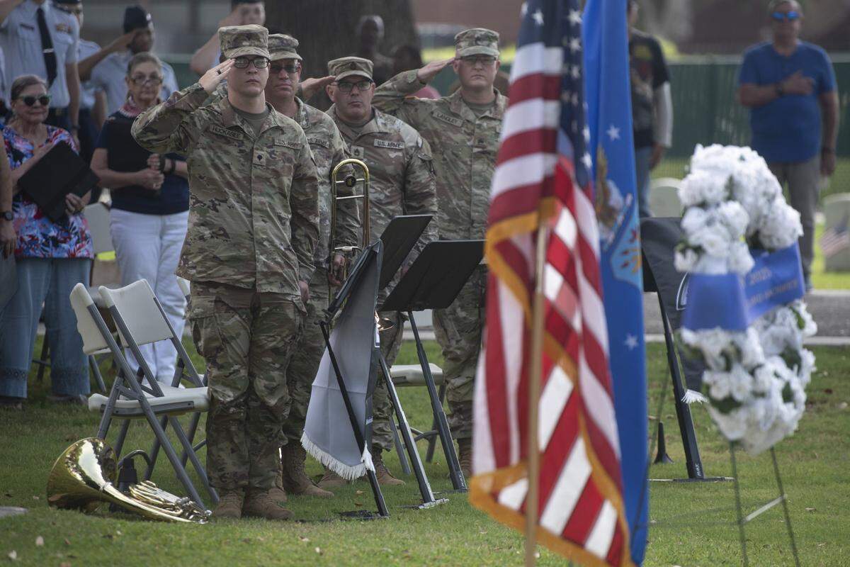 Members of the 41st Army Band salute the flag during a Memorial Day ceremony at Biloxi National Cemetery in Biloxi on Monday, May 26, 2025.