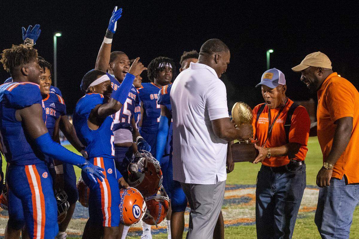 Gulfport City Councilman Truck Casey presents the Port City Bowl trophy to the Gulfport Admirals after they defeated George County at Milner Stadium in Gulfport on Saturday, Aug. 27, 2022.
