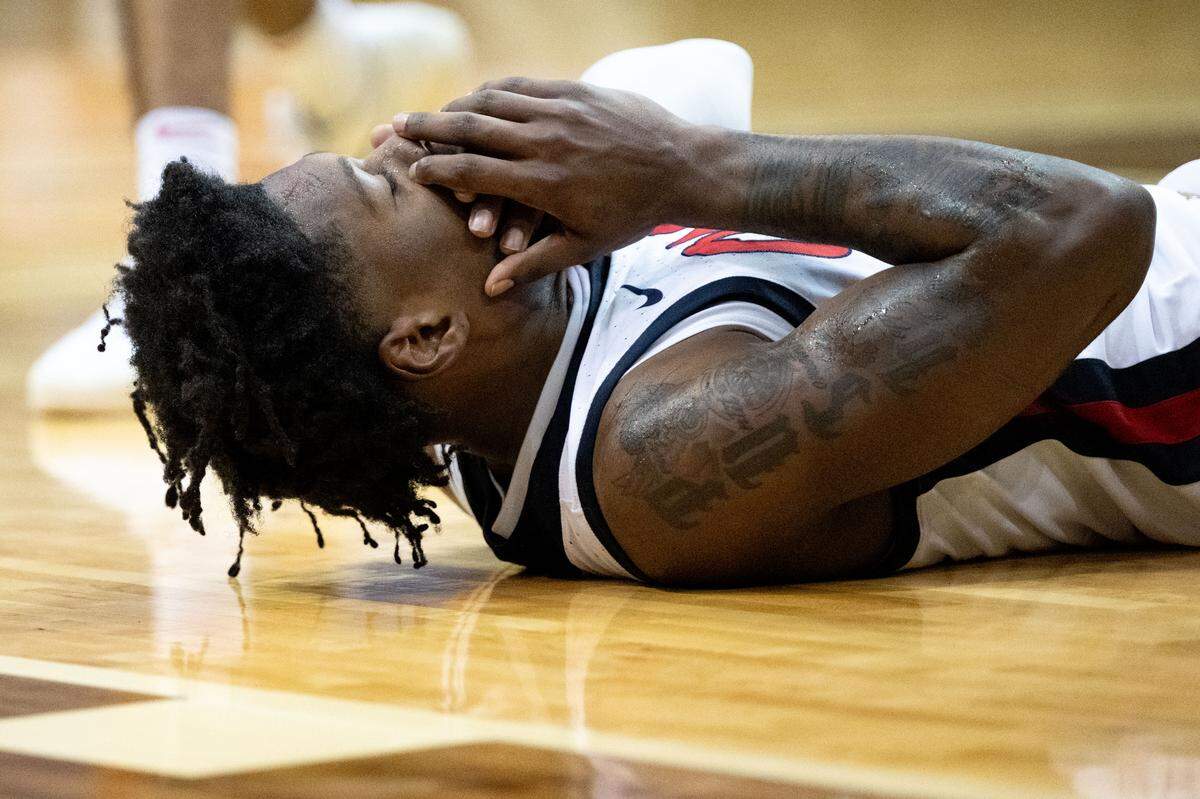 Mississippi guard AJ Storr (2) holds his face as he falls to the ground.