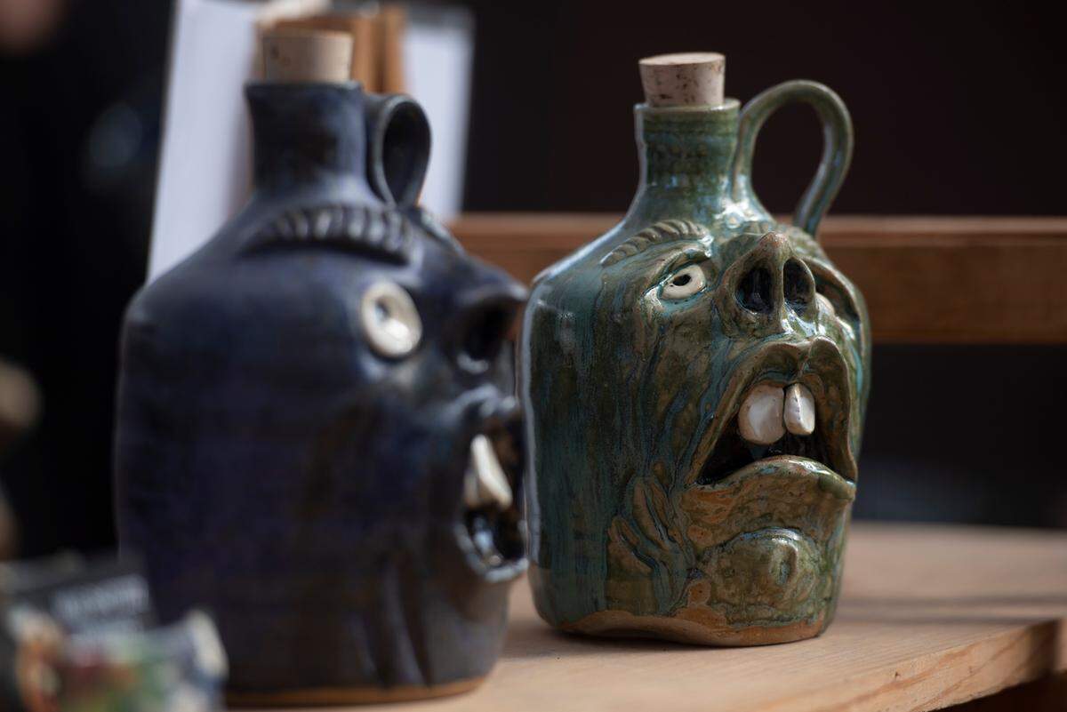 Vases decorated with facial expressions for sale during the Peter Anderson Festival in Ocean Springs on Sunday, Nov. 6, 2022.