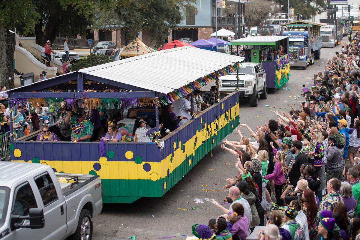 Parade watchers on Lameuse Street cheer for beads and other throws during the Gulf Coast Carnival Association Mardi Gras parade in Biloxi on Tuesday, March 4, 2025.