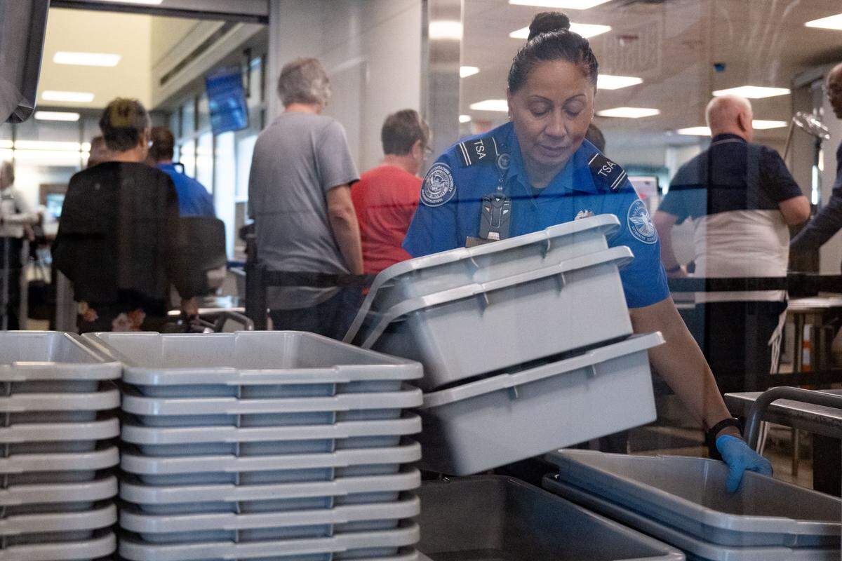A TSA officer organizes bins at a security checkpoint at Gulfport-Biloxi International Airport on Wednesday.