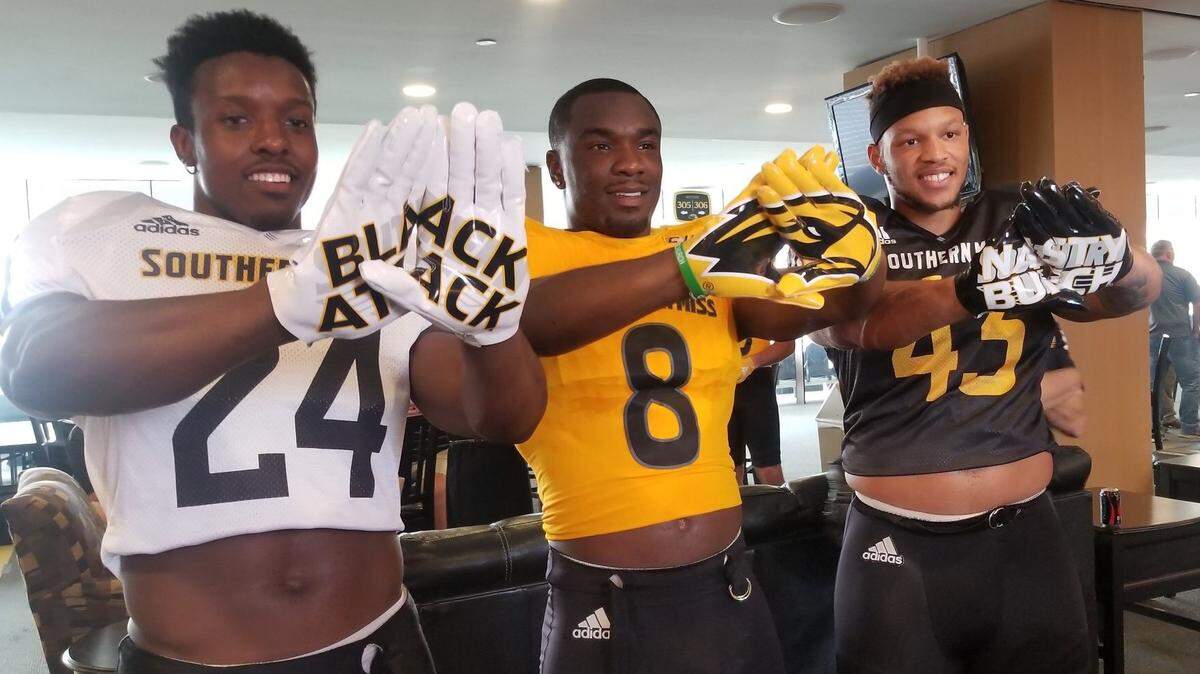 Southern Miss running back George Payne, running back Tez Parks and defensive lineman LaDarius Harris pose in USM’s new Adidas uniforms on Thursday in Hattiesburg.