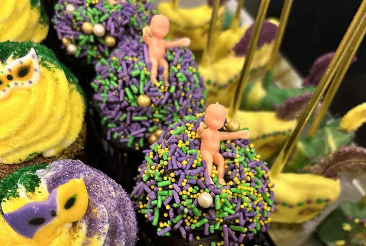 King cake babies are perched in a bed of colorful Mardi Gras sprinkles in these cupcakes from the bakery at Hollywood Casino Gulf Coast.