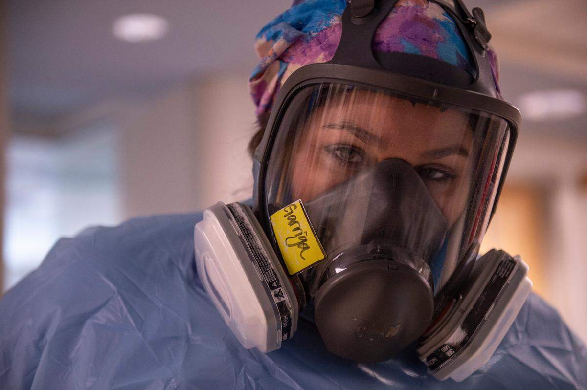 A nurse puts on a gas mask before entering a COVID-19 patient’s room in the ICU at Memorial Hospital in Gulfport on Wednesday, Aug. 11, 2021.