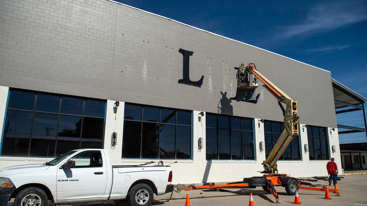 Workers hang up letters for the restaurant sign on the side of the future Sully’s restaurant in Gulfport on Tuesday, Nov. 9, 2021.