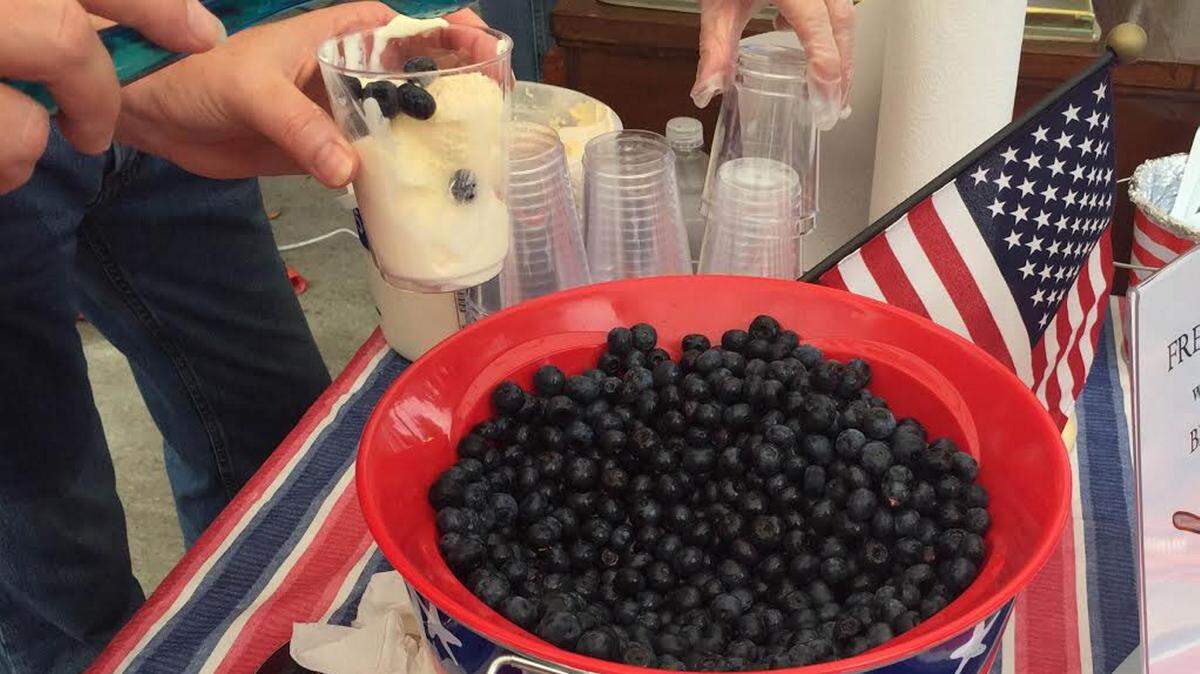 JOHN FITZHUGH/SUN HERALD 
 Volunteers serve ice cream with blueberries at the Ocean Springs Chamber of Commerce tent at the Red, White & Blueberry Festival on Saturday, June 4, 2016.