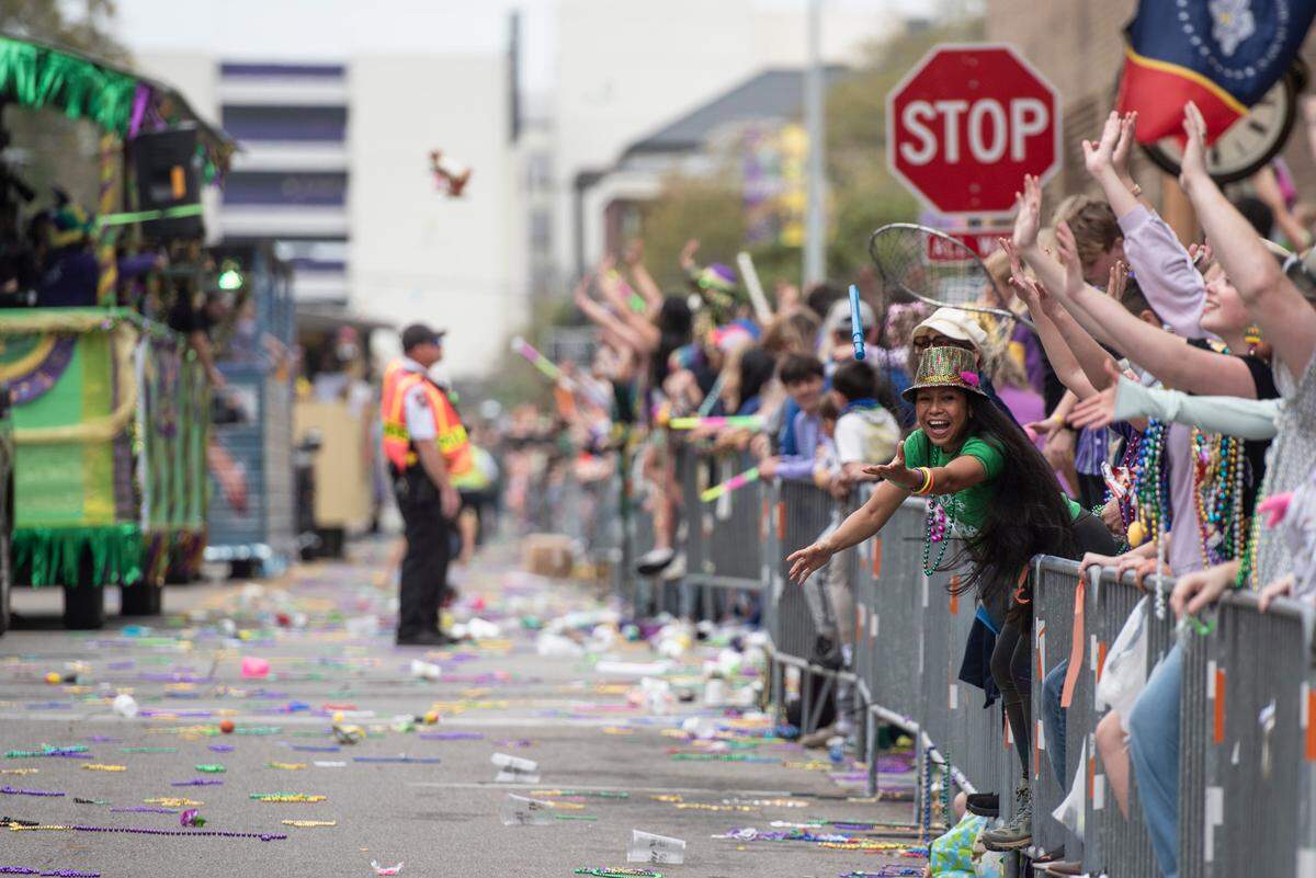 Parade watchers catch beads and other throws during the Gulf Coast Carnival Association Mardi Gras parade in Biloxi on Tuesday, March 4, 2025.