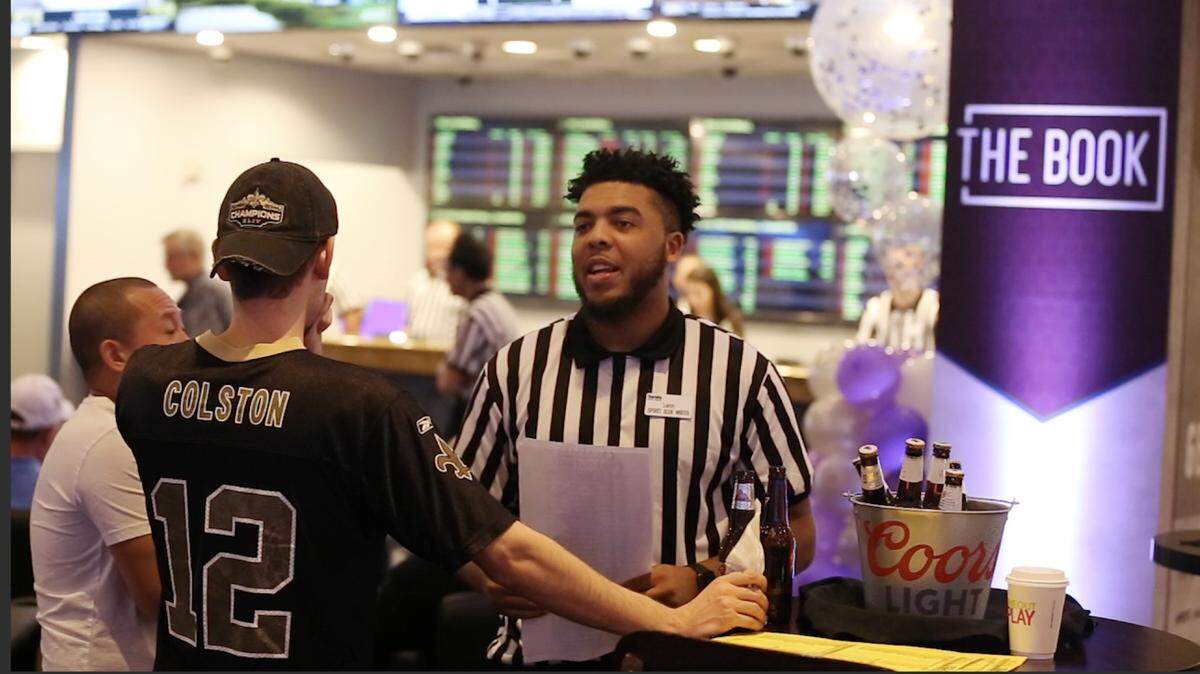 A sports book writer talks to customers at the sports book at Harrah’s Gulf Coast Hotel & Casino Biloxi on Monday, Aug. 20, 2018. 