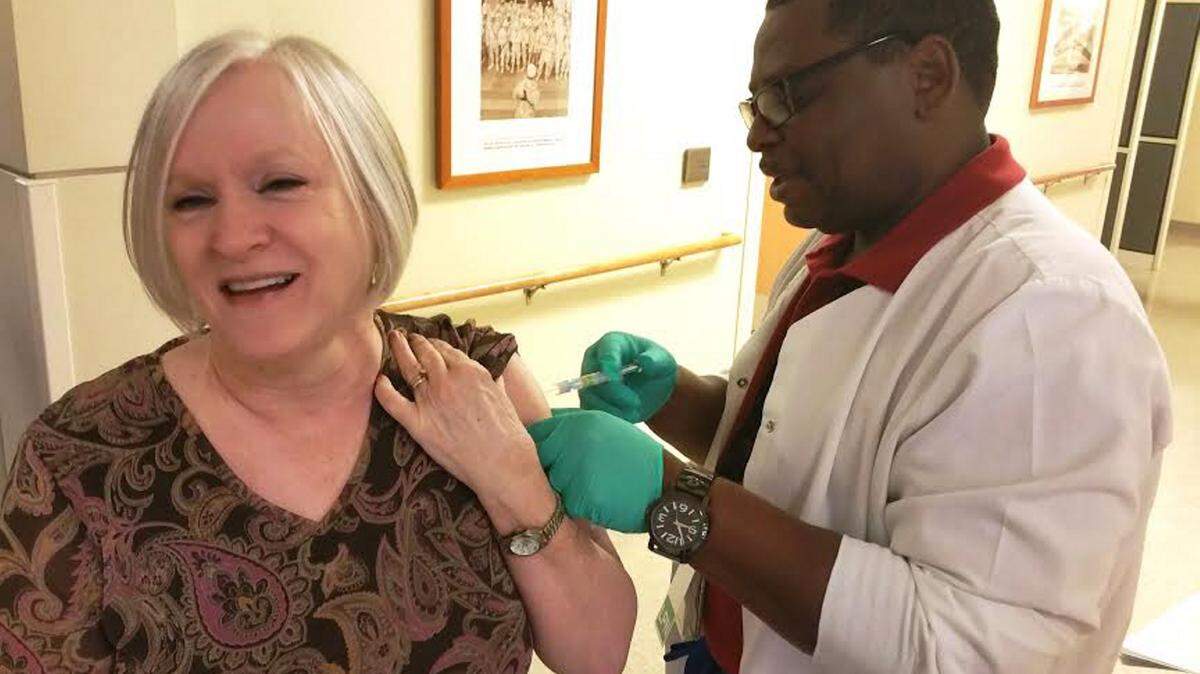 Veteran Cathy Carey holds still as Gulf Coast Veterans Health Care System Licensed Practical Nurse Rick Hobbs gives her a flu shot in the lobby of the Joint Ambulatory Care Center in Pensacola, Fla., on Oct. 5. Flu shots are available to eligible and enrolled veterans at all GCVHCS facilities. (Jerron Barnett/Sumbitted)