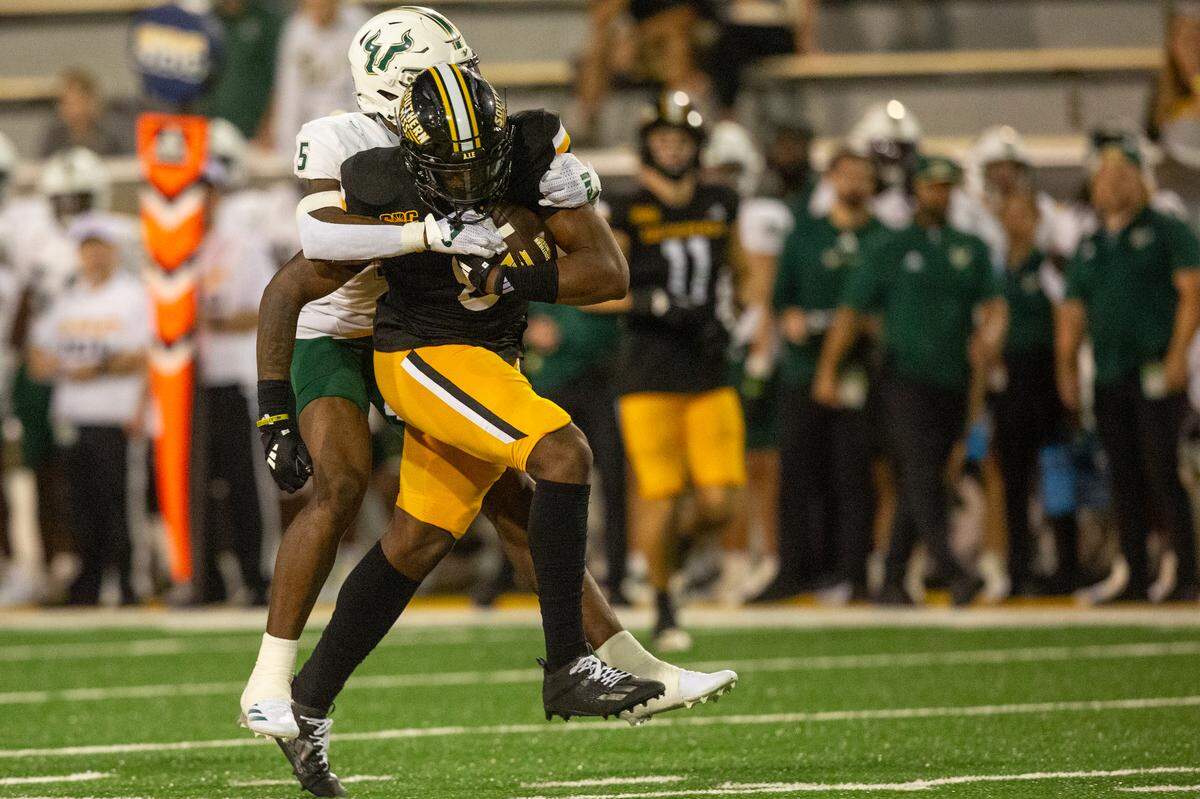 Southern Miss Golden Eagles running back Derek Clark (0) gets tackled by South Florida Bulls safety Caqavouis Berryhill (5) during a game between Southern Miss and South Florida at M.M. Roberts Stadium in Hattiesburg on Saturday, Sept. 14, 2024.