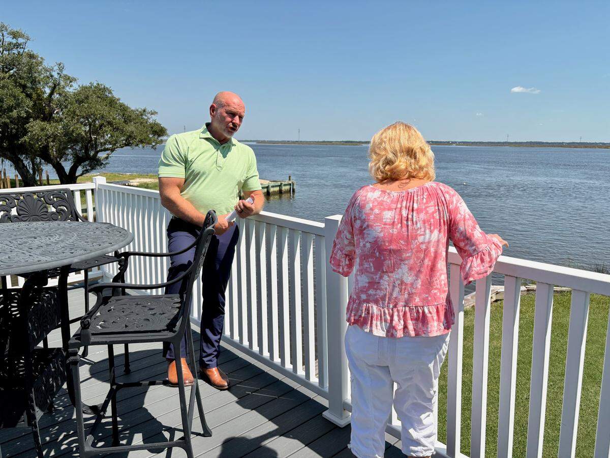 Andy Case of the Mississippi Insurance Department, who oversees a pilot program to fortify roofs against hurricane damage, talks with participant Brenda Sanders of Gautier. Sanders said that she and her husband are pleased with their stronger roof and the insurance discount they received. The program offered a $10,000 grant to each of the 28 participating homeowners.