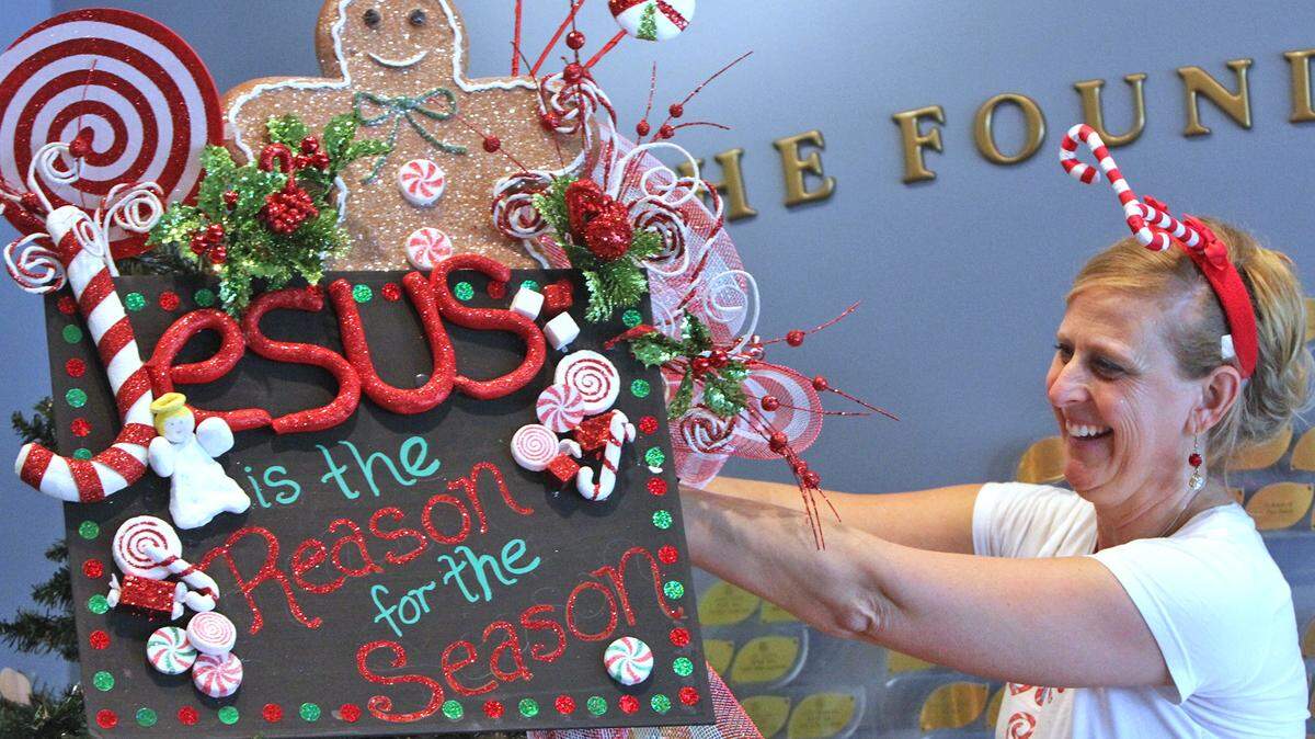 JOHN FITZHUGH/SUN HERALDHoly Trinity Catholic School art teacher Michelle Logan decorates the school's tree at the Hancock County Library in Bay St. Louis on Monday.