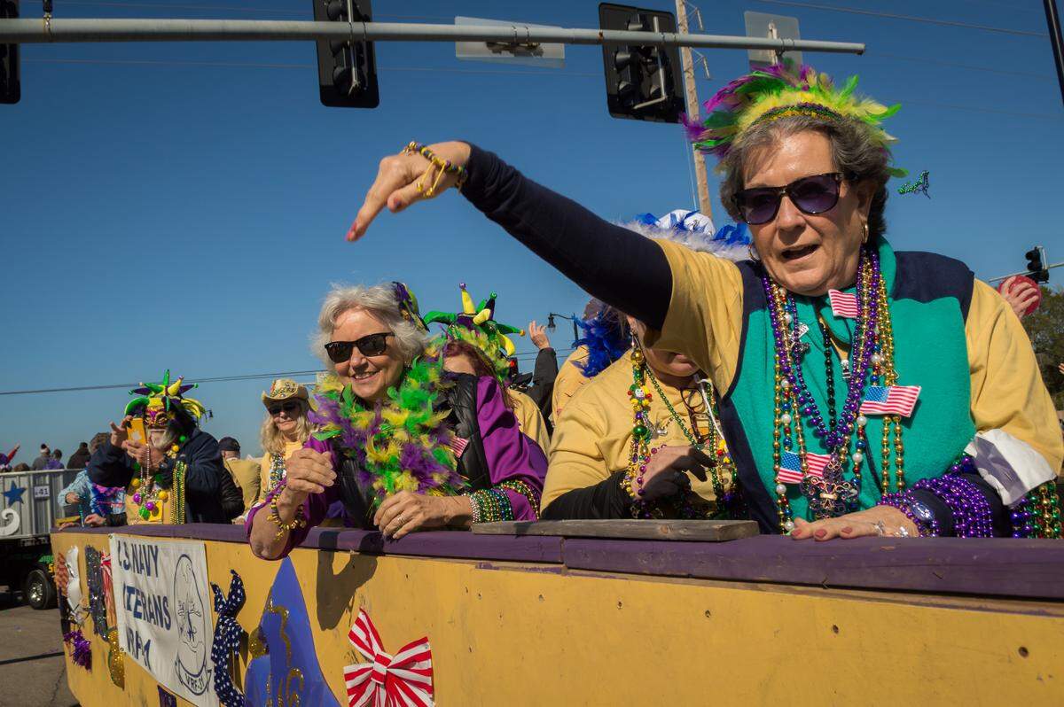 Throws to the crowds from the US Navy Veterens float during the Krewe of Gemini Day parade in Gulfport on Saturday, Feb. 22, 2020.