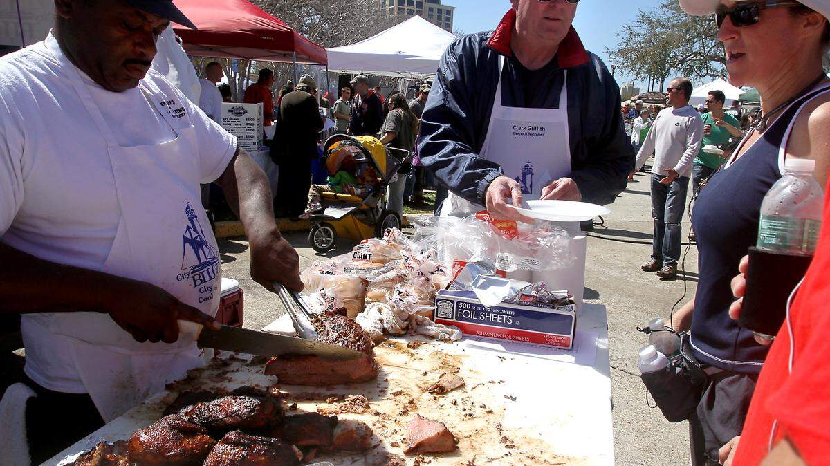 AMANDA McCOY/SUN HERALD/FILECooking teams serve up some barbecue during a past Grillin' on the Green. This year's event is Saturday at the Town Green in Biloxi.