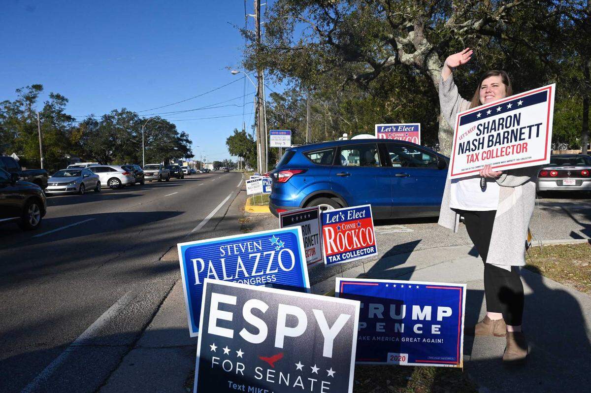 Julie Barnett waves a sign to campaign for her stepmother, Sharon Nash Barnett, outside of the Donal Snyder Senior Community Center in Biloxi. Barnett is running for Tax Collector against Connie Rockco, Sheena Khalifeh, Scottie Cuevas, and Jennifer Adams. A garden of signs popped up on Election Day, Nov. 3, 2020, outside Donal Snyder Community Center on Pass Road in Biloxi.
