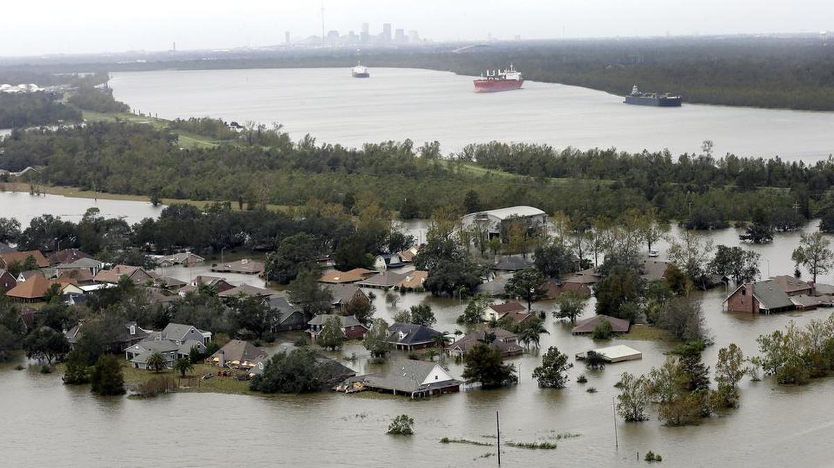 In this Aug. 31, 2012 file photo, the town of Braithwaite, La., is inundated with floodwaters from Isaac as downtown New Orleans is visible in the distance. Isaac barely had hurricane-strength winds when it blew ashore southwest of New Orleans a year ago, but its effects are still apparent in coastal areas where it flooded thousands of homes. After landfall on Aug 28, 2012, Isaac stalled, dumping more than a foot of rain and churning a monstrous storm surge. Water flowed over levees and destroyed homes and businesses in coastal Louisiana and Mississippi.