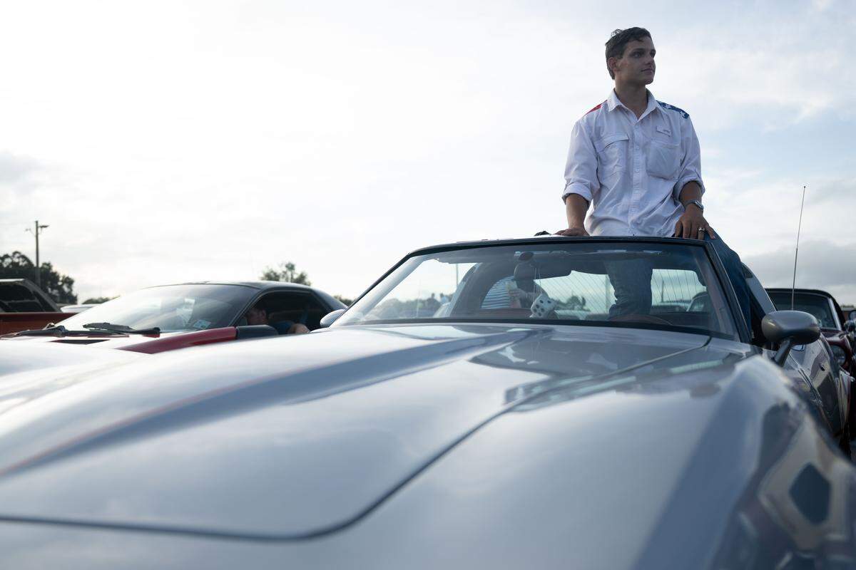 Nate Goff sits on top of his 1982 Chevy Corvette as he waits for the Long Beach Cruisin’ The Coast Parade to start.
