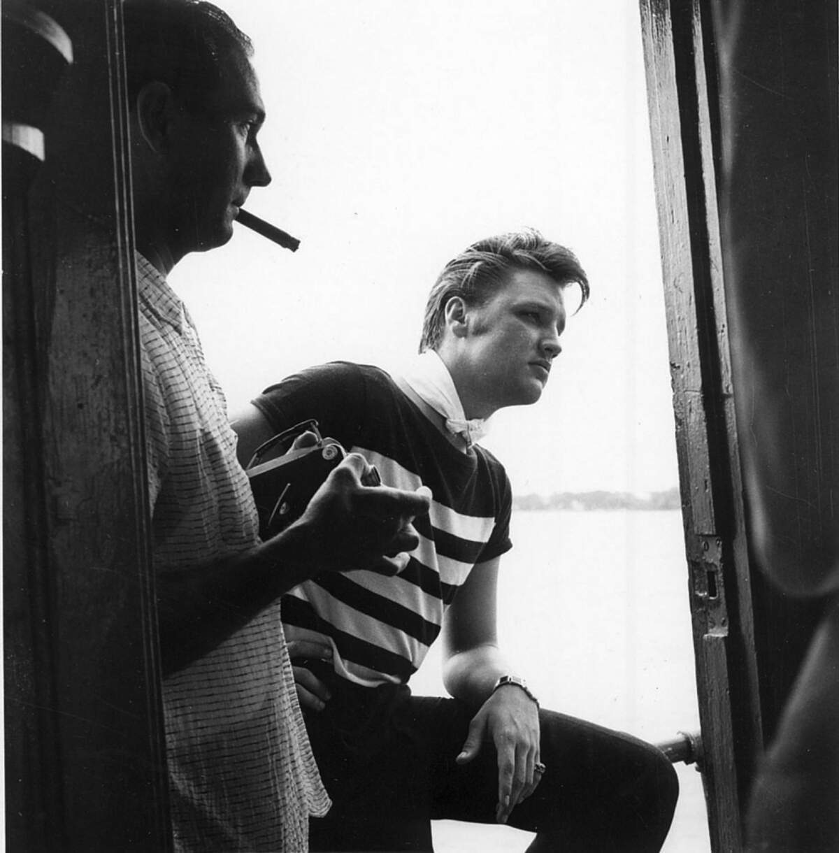 Elvis Presley in Biloxi aboard the deep sea fishing charter boat Aunt Jennie on July 12, 1956, just after a big shark broke his line. Biloxi business man Eddie Bellman smokes a cigar and holds the movie camera with which he took rare film footage of the up-and-coming star. Mississippi Gulf Coast Community College C.C. “Tex” Hamill Down South Magazine Collection.