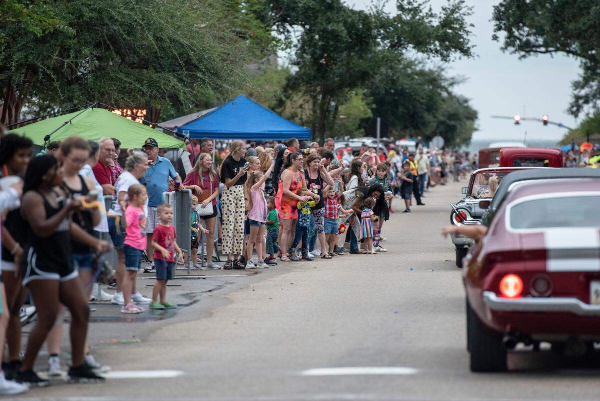 Crowds cheer as cars drive down Jeff Davis Avenue in Long Beach during the 2021 parade that is a favorite Cruisin’ The Coast event.