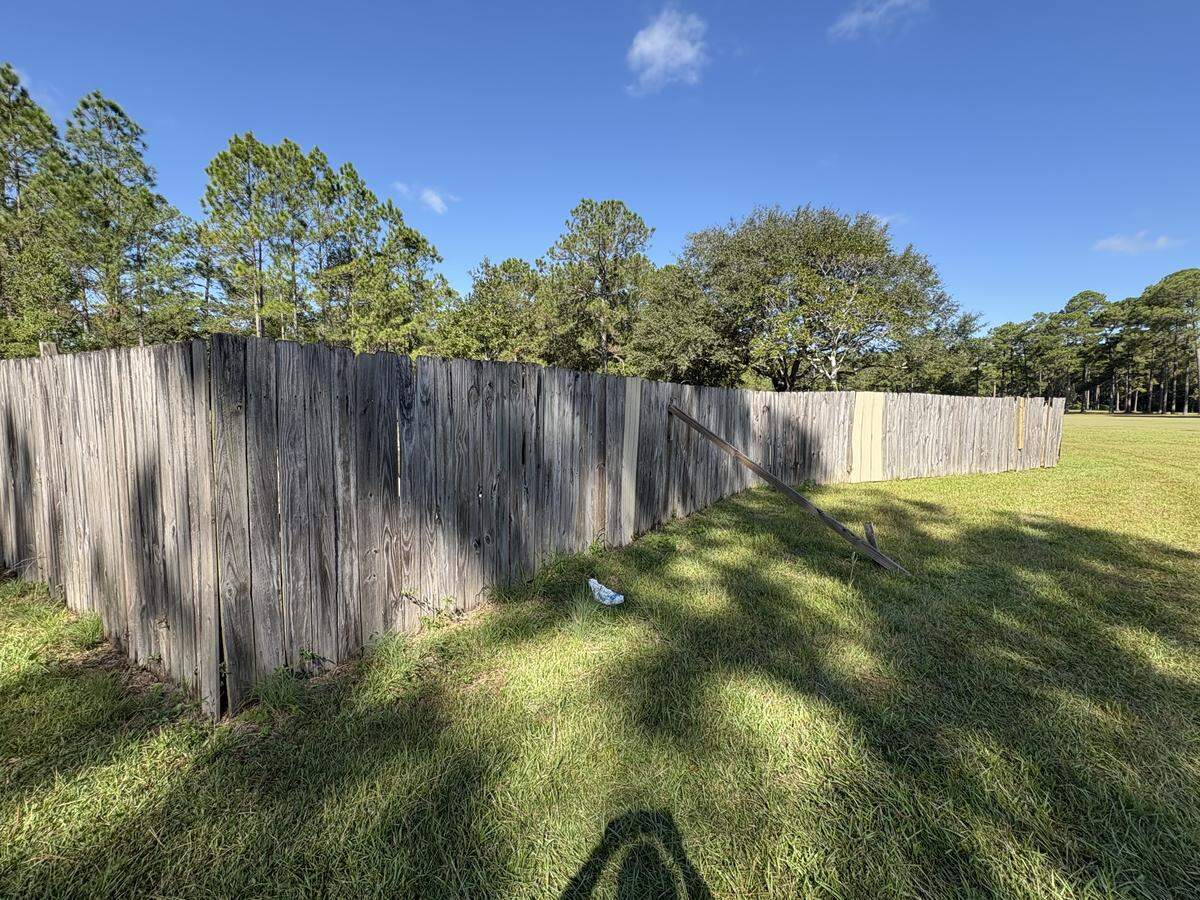 A tall wood fence surrounds the unused pool where authorities said two children were found unresponsive on Monday Oct. 20, 2025.