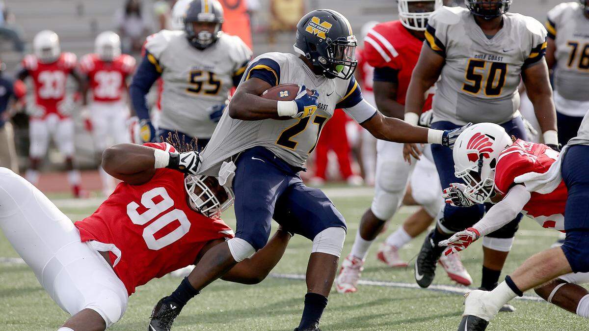 AMANDA McCOY/SUN HERALD 
 Itawamba Community College's Ladarius Gallion, left, and Cartin McBride, right, attempt to stop Mississippi Gulf Coast Community College linebacker Malcolm Conn tackles Itawamba Community College running back Walter Williams on Saturday, October 24, 2015, in Perkinston.
