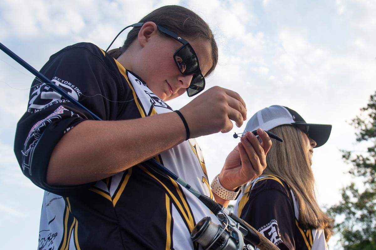 D’Iberville Bass Fishing Team member Olivia King, left, puts bait on her line while fishing on the Tchoutacabouffa River in D’Iberville on Monday, June 3, 2024.
