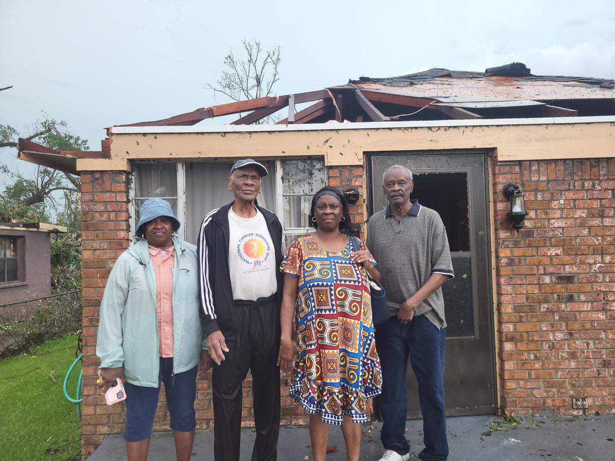 Dorine Watson Lyne, 64, Ernest Watson III, center, and other family and friends stand in front of Ernest’s home on East Bayou Avenue in Moss Point. The house sustained heavy damage from a tornado.