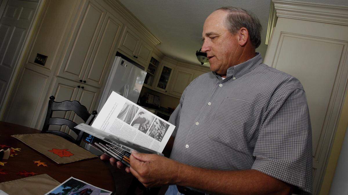 Joe Lyons looks over a magazine article featuring his brother Phil Lyons in 2008.  Phil was murdered in Gulfport in 2002, and the case remains cold.