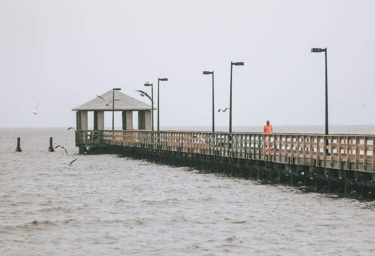 A lone person checks the conditions along the Biloxi Lighthouse Pier Wednesday morning before the Coast begins to feel the effects of Hurricane Zeta Oct. 28, 2020. The end of the pier was destroyed by Tropical Storm Cristobal in June and has not yet been replaced.
