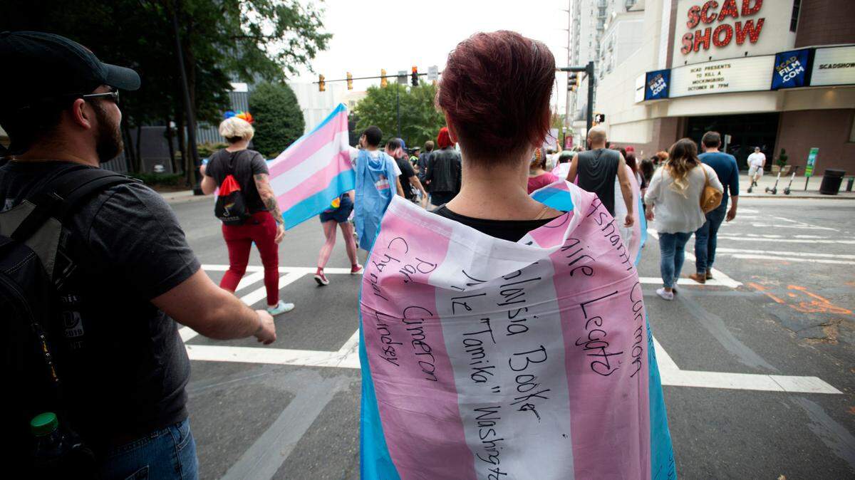 A supporter for the transgender and non-binary community, wearing a transgender flag with handwritten names of Black trans women who the person said were killed in 2019. Mississippi Gov. Tate Reeves criticized President Joe Biden’s latest executive action protecting LGBTQ people from discrimination based on sexual orientation and gender identity. (AP Photo/Robin Rayne)