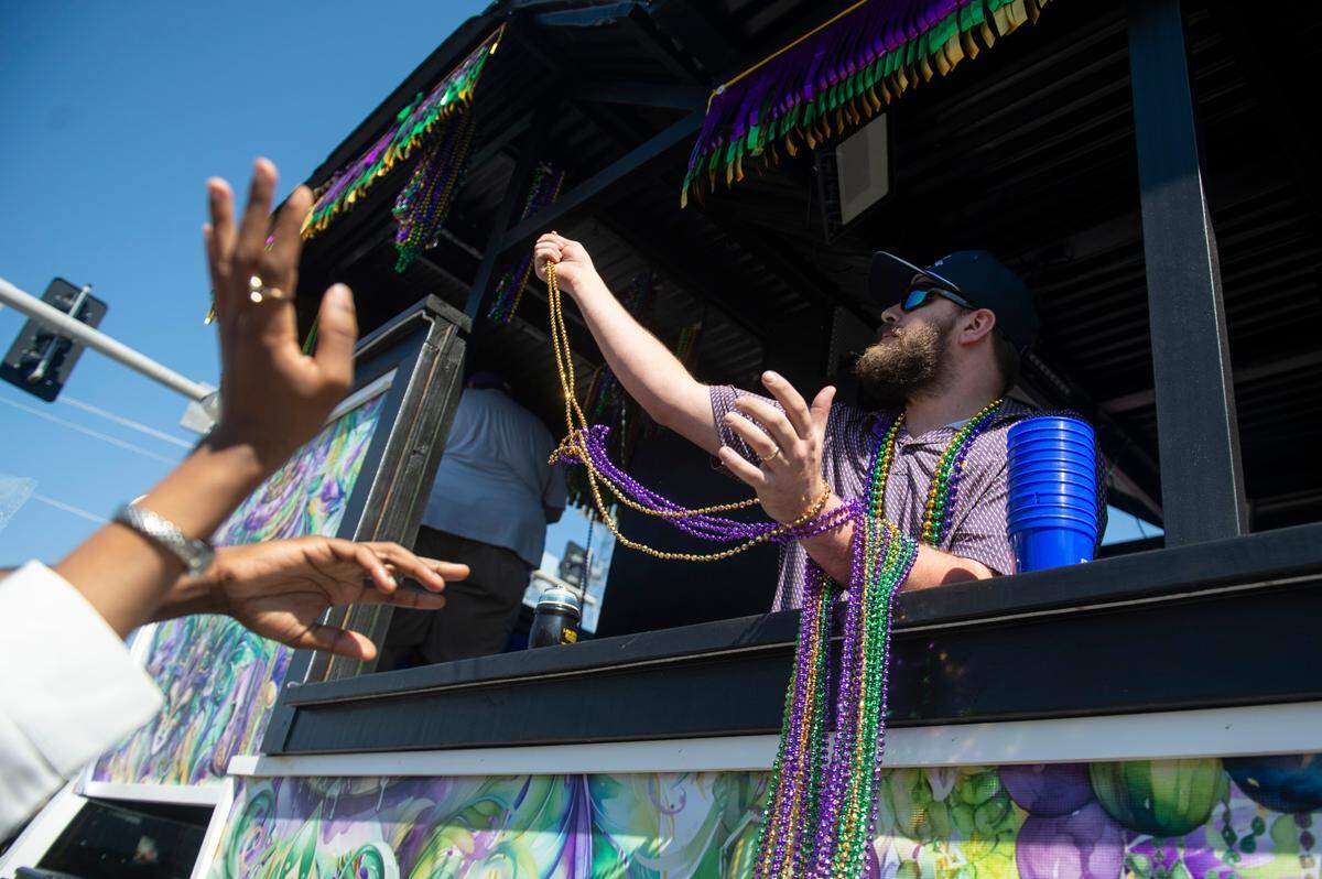 Krewes toss beads and other throws during the Jackson County Carnival Association Mardi Gras parade in Pascagoula on Saturday, March 1, 2025.