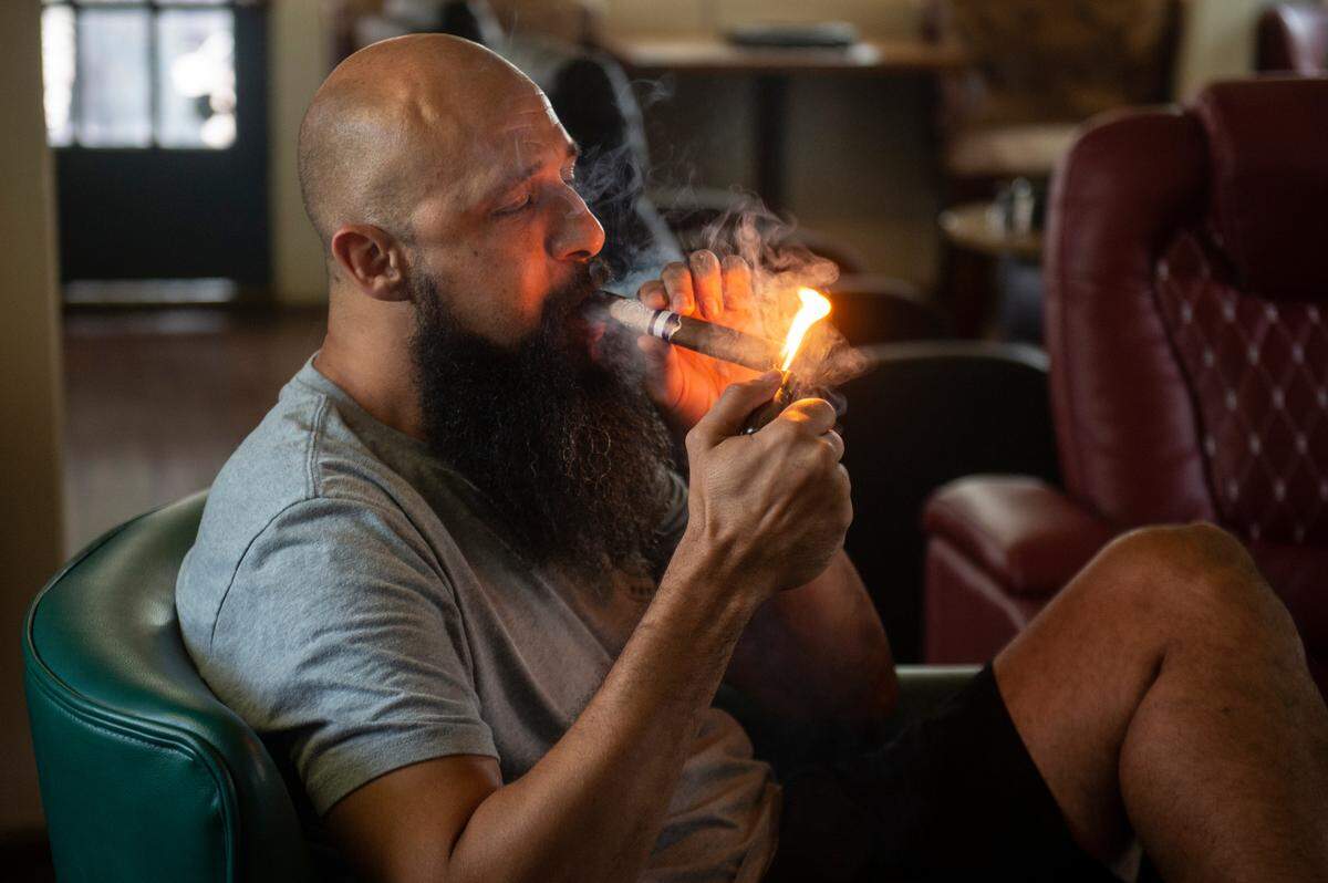 Cigars in the Pass owner Clifton Williams lights a cigar as he sits in the lounge area at Cigars in the Pass in Pass Christian on Tuesday, June 27, 2023.