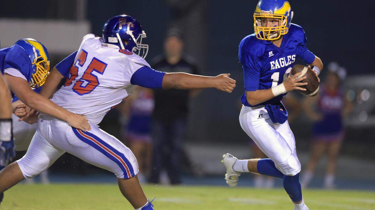 GLENN ANDREWS/SPECIAL TO THE SUN HERALD 
 Resurrection Catholic quarterback Blake Porter (10) rolls away from the pressure of Pass Christian guard Justin Kidd (65). The Eagles host Lumberton in the 1A South state finals at 7 p.m. Friday.