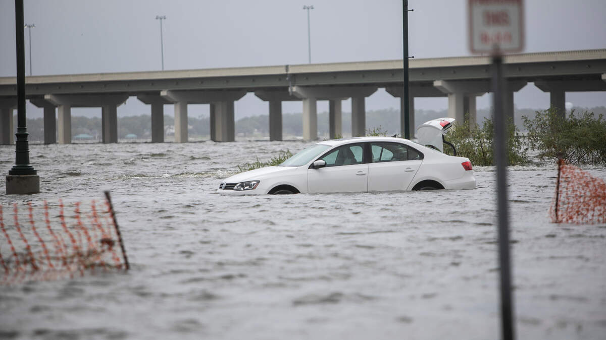 A car is flooded in water with the trunk popped open at Point Cadet Plaza in East Biloxi ahead of Hurricane Ida.