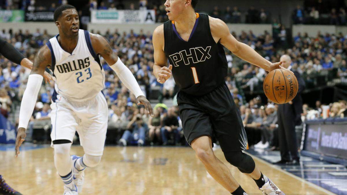 Dallas Mavericks guard Wesley Matthews (23) gives chase as Phoenix Suns guard Devin Booker (1) moves the ball up court during an NBA basketball game, Sunday, Jan. 31, 2016, in Dallas. (AP Photo/Tony Gutierrez)