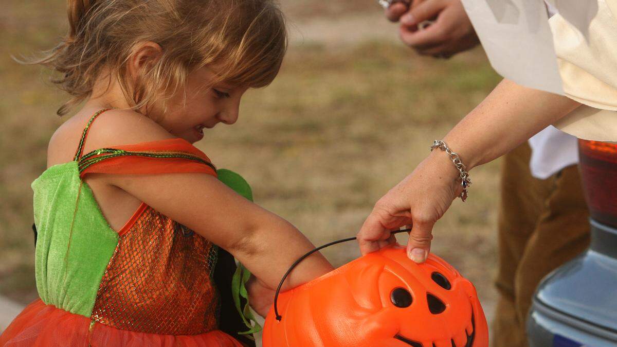 WILLIAM COLGIN/SUN HERALD 
 McKenzie Maxwell, 6, reaches into a goody back for some candy during the Trunk or Treat event put on by the First United Methodist Church of Gulfport on Sunday.