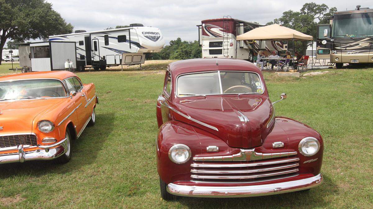 JOHN FITZHUGH/SUN HERALD 
 A group of Cruisin' The Coast visitors from Louisiana relax under their tent on a piece of land in Biloxi on Friday Oct. 2, 2015. The cars are a 1955 Chevrolet Bel Air owned by Bobby and Cheri Baucher of Slidell, left, and a 1946 Ford coupe owned by Bill and Bonnie Dekemel of Slidell.
