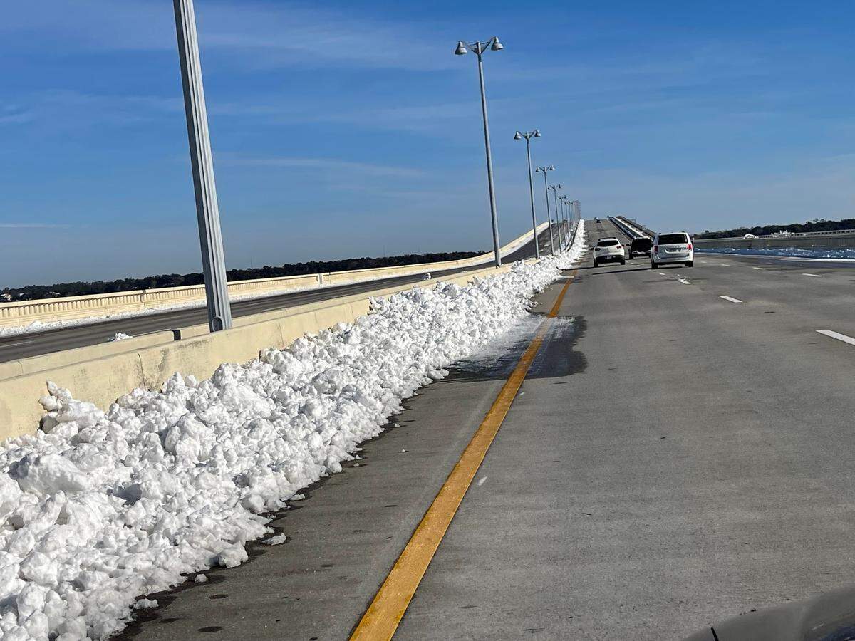 Snow is piled up on the side of the road Thursday, Jan. 23, 2025, on the Biloxi Bay Bridge after snow plows came through Wednesday. A few icy patches remained on the bridge Thursday morning. Emergency responders urged motorists to drive slow.