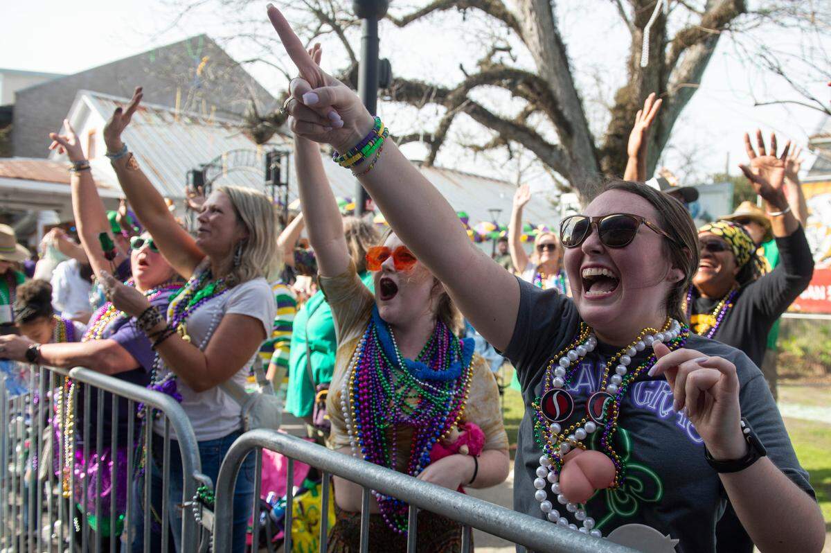 Parade watchers cheer for throws during the Ocean Springs Elks Club Mardi Gras Parade in Ocean Springs on Saturday, Feb. 15, 2025.