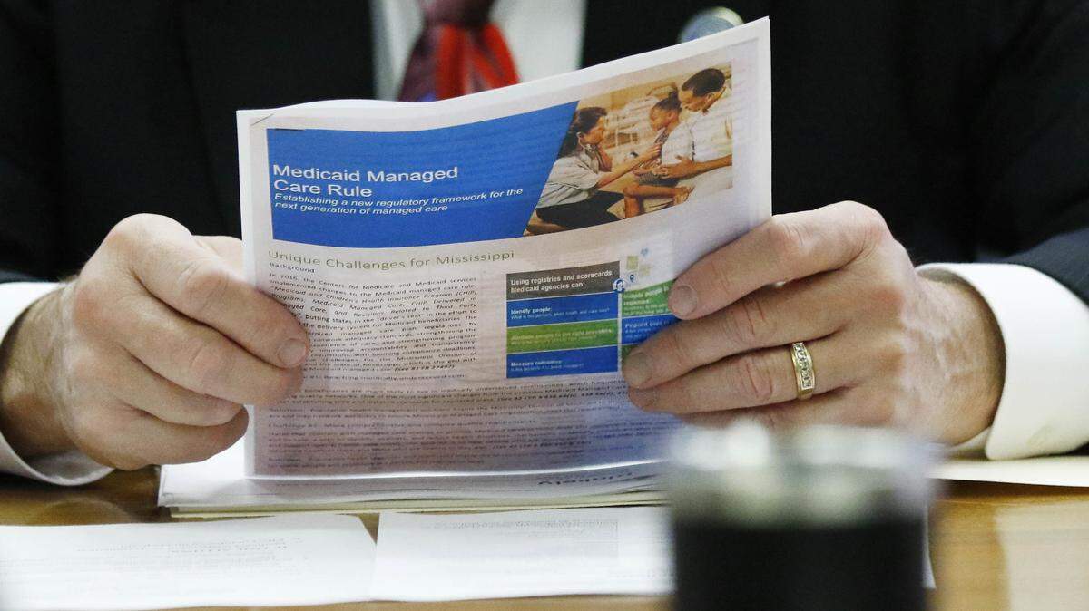 A member of the Senate Medicaid Committee reviews a Medicaid handout that reviews the managed care rule, Wednesday, Jan. 24, 2018, at the Capitol in Jackson, Miss.