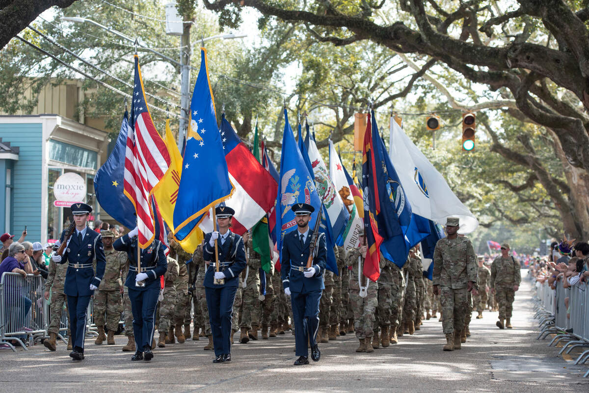 Members of the armed forces march during the Ocean Springs Elks Club Mardi Gras Parade in Ocean Springs on Saturday, Feb. 15, 2025.